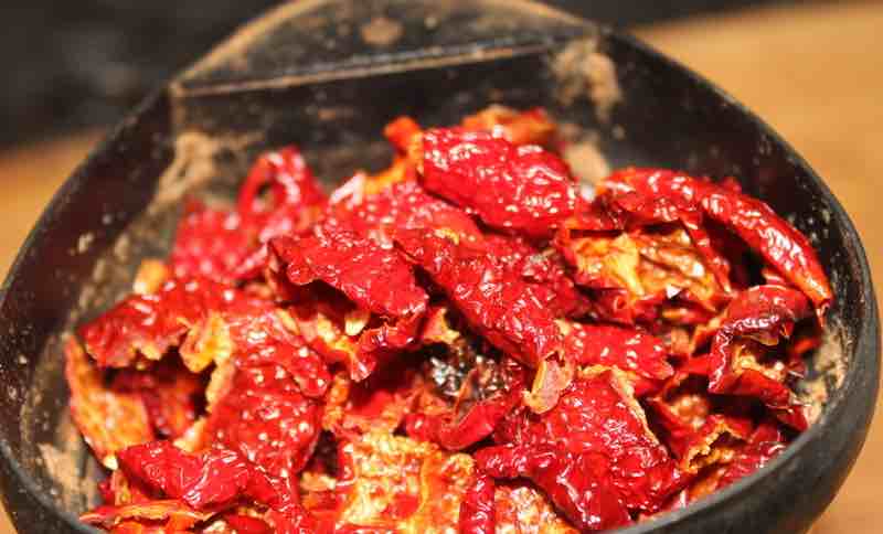 Dried Hilton Peppadew flakes in the grinder. Dried Hilton Peppadew flakes in the grinder.