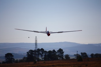 Bernie's glider landing after just clearing the high tension cables. Bernie's glider landing after just clearing the high tension cables.