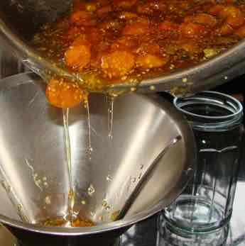 Gooseberry jam pouring into jars. Gooseberry jam pouring into jars.