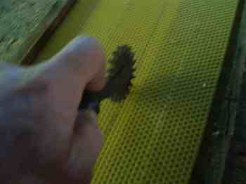 Imbedding the wire into the foundation wax in the frames. Imbedding the wire into the foundation wax in the frames.